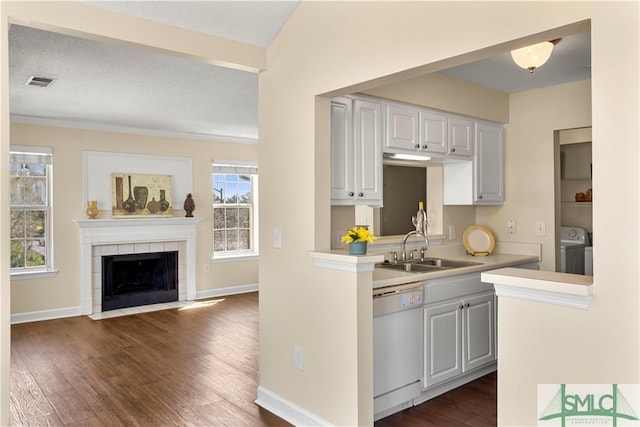 kitchen with visible vents, washer and clothes dryer, dishwasher, light countertops, and a sink