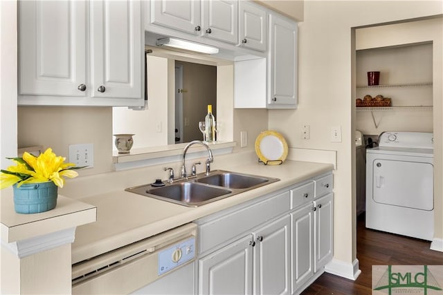 kitchen with light countertops, white dishwasher, dark wood-style floors, white cabinets, and a sink