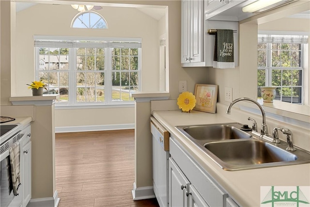 kitchen with plenty of natural light, dishwasher, light countertops, and a sink