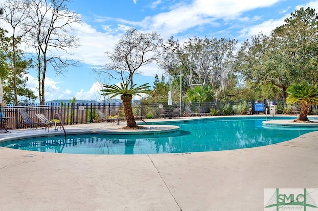 pool with a patio and fence