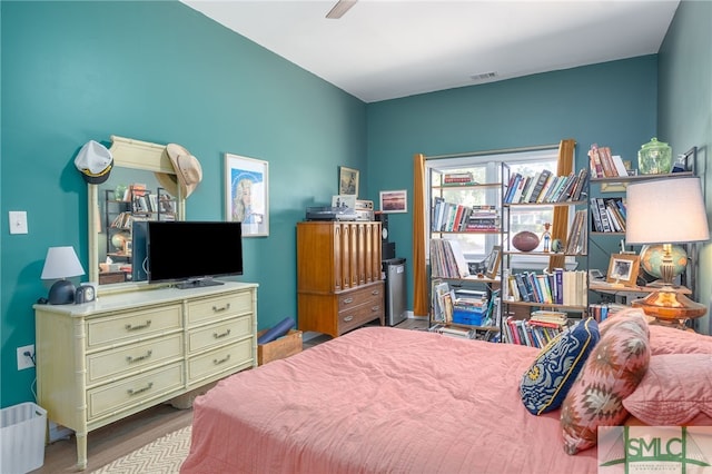 bedroom featuring ceiling fan, visible vents, and wood finished floors