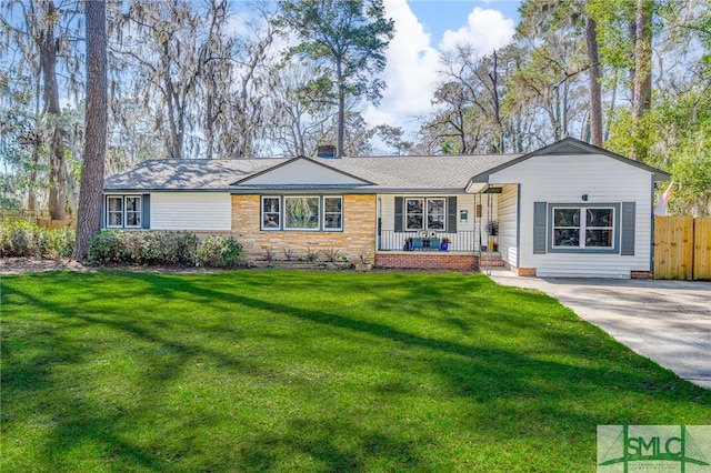 ranch-style house featuring a porch, a front yard, and fence