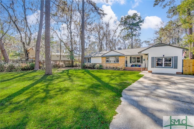 single story home featuring concrete driveway, a front lawn, and fence