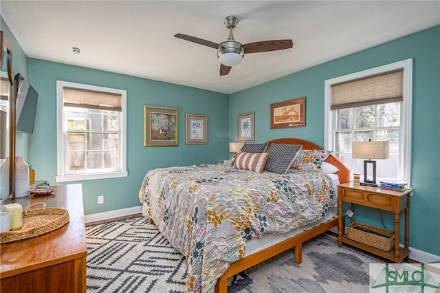 bedroom with a ceiling fan and baseboards
