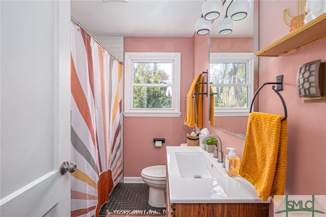 full bath with curtained shower, toilet, vanity, and baseboards