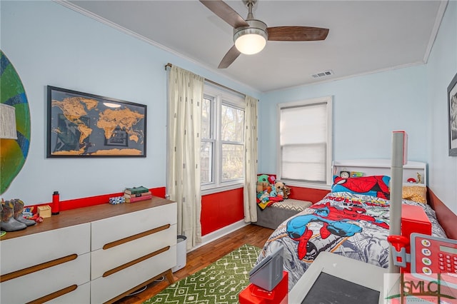 bedroom featuring visible vents, crown molding, ceiling fan, and wood finished floors