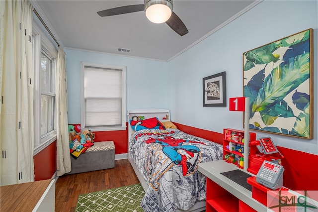 bedroom with ceiling fan, wood finished floors, visible vents, and ornamental molding