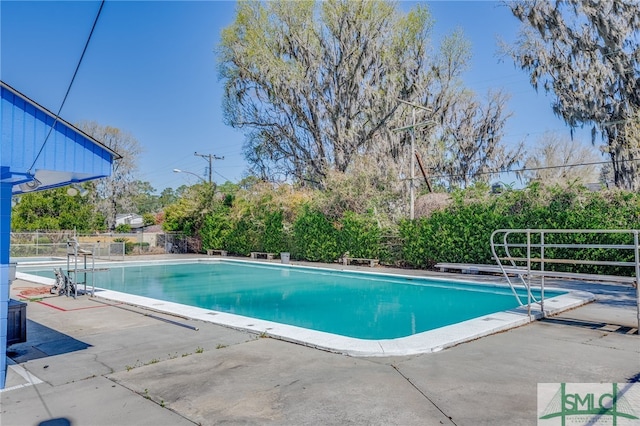 view of swimming pool featuring a patio area, a fenced in pool, and fence