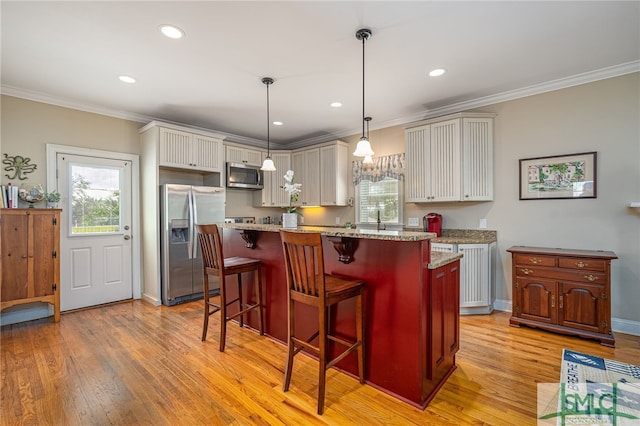 kitchen with appliances with stainless steel finishes, light wood-type flooring, a kitchen breakfast bar, and crown molding