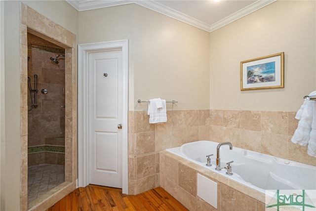 bathroom featuring a bath, tiled shower, crown molding, and wood finished floors