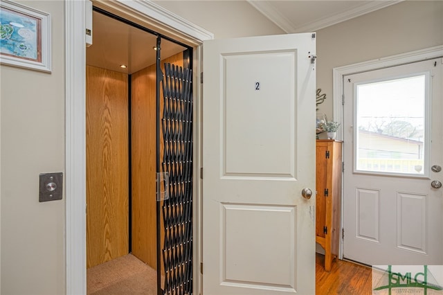 entryway featuring crown molding, elevator, and wood finished floors