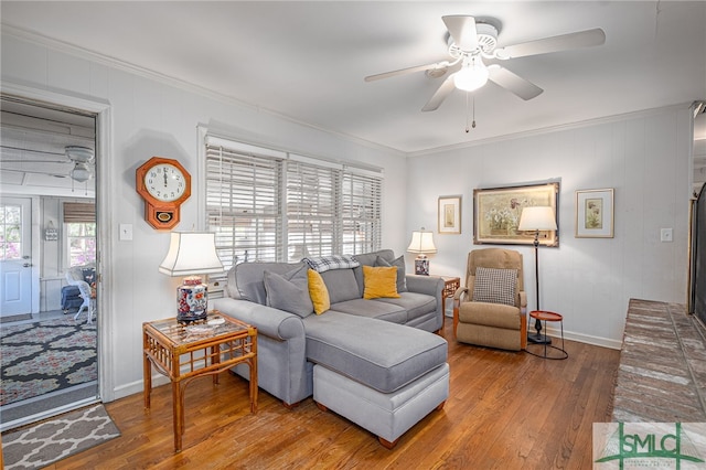 living room featuring baseboards, crown molding, a ceiling fan, and hardwood / wood-style flooring