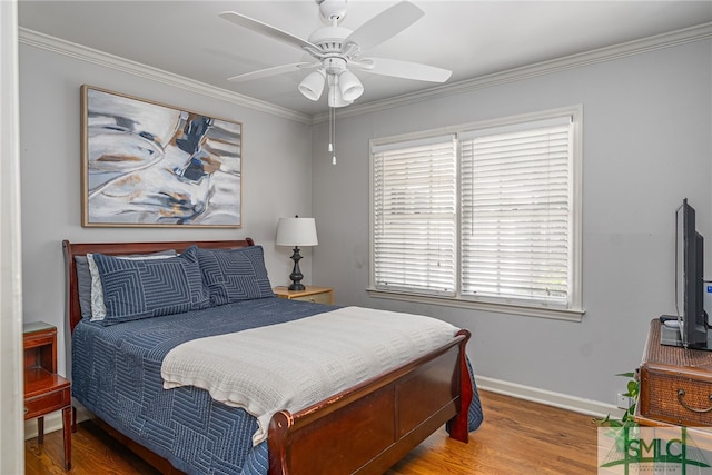 bedroom with a ceiling fan, crown molding, baseboards, and wood finished floors