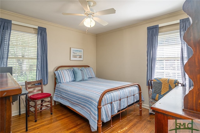 bedroom with baseboards, wood finished floors, and crown molding