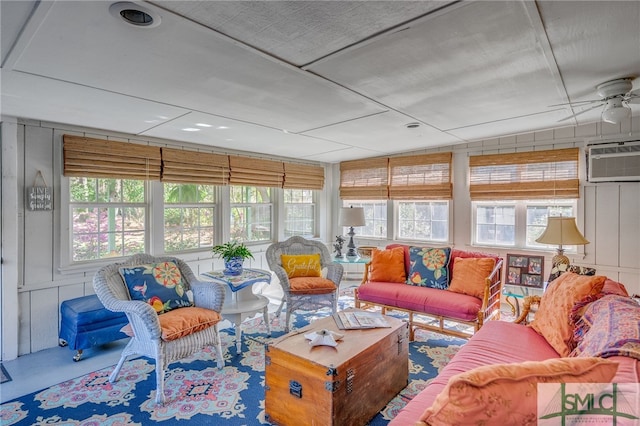 sunroom with an AC wall unit and a ceiling fan