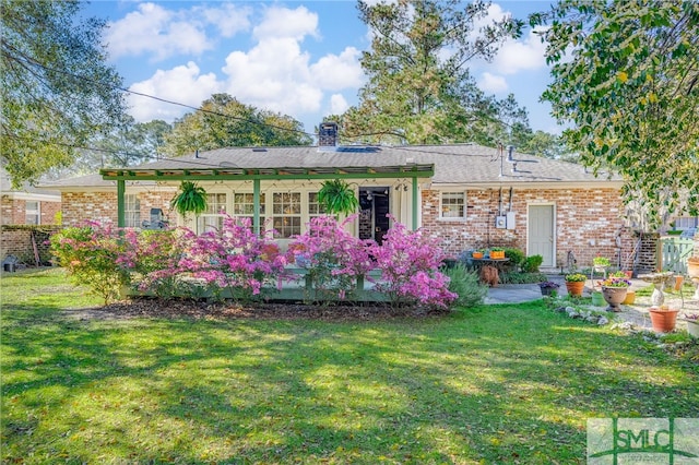 back of house featuring brick siding and a lawn