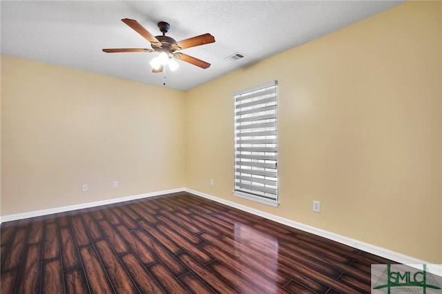 empty room featuring visible vents, ceiling fan, dark wood-type flooring, and baseboards