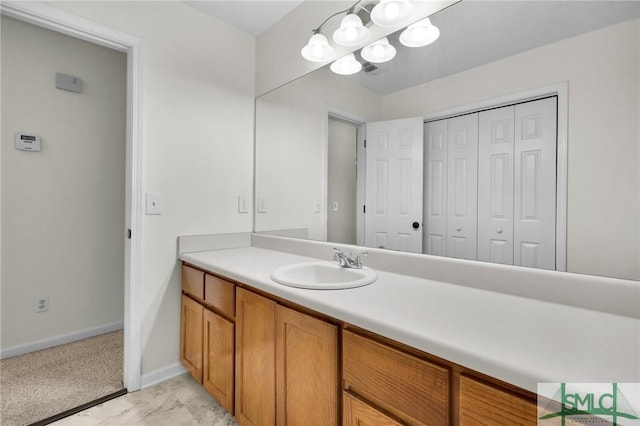 bathroom featuring marble finish floor, vanity, and baseboards