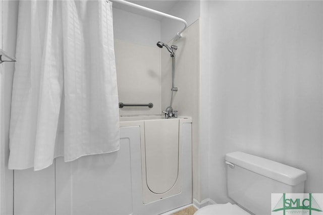 bathroom with a shower with curtain and toilet