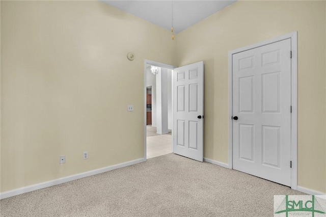 unfurnished bedroom featuring baseboards and light carpet