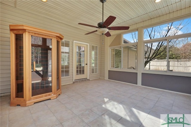 unfurnished sunroom featuring wooden ceiling and ceiling fan