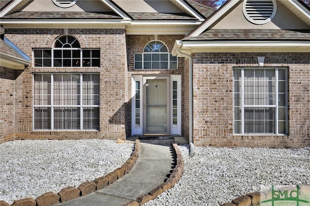 doorway to property with brick siding