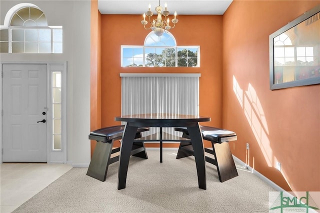 interior space featuring a chandelier, baseboards, and a towering ceiling