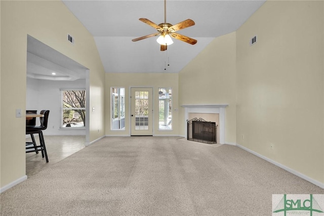 unfurnished living room with visible vents, a fireplace with flush hearth, a ceiling fan, carpet, and baseboards