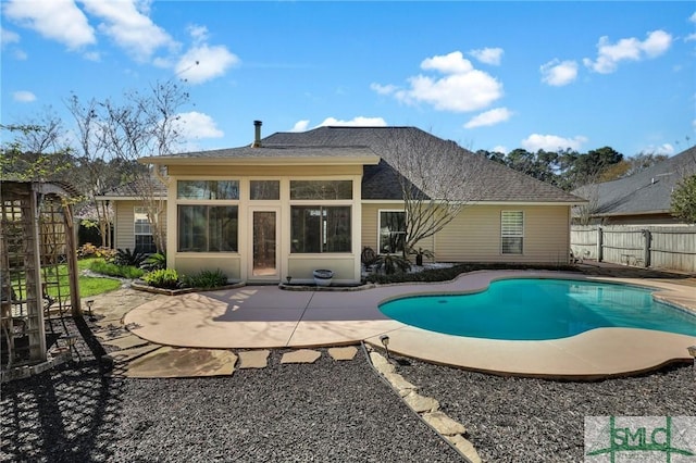 back of property featuring a patio area, a fenced in pool, roof with shingles, and fence