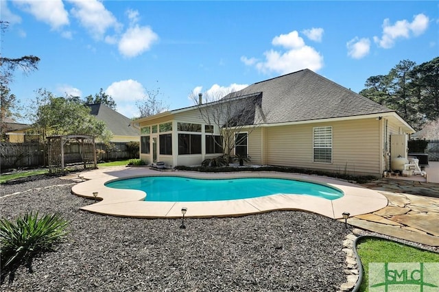 view of swimming pool with a fenced in pool, a sunroom, a fenced backyard, and a patio area