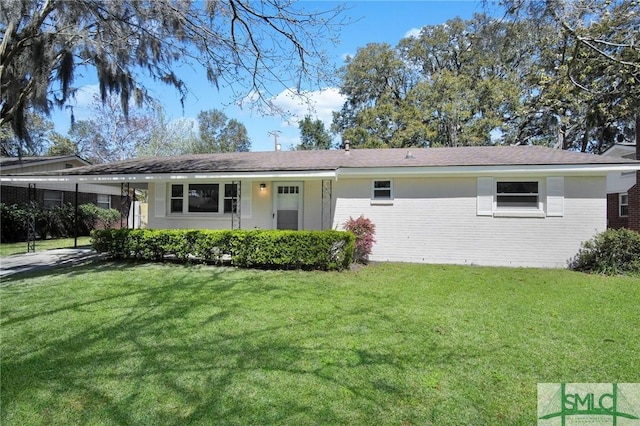 single story home with a carport, brick siding, and a front lawn