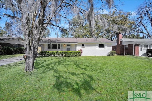 single story home with a front yard, brick siding, and a chimney