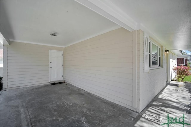 doorway to property with an attached carport