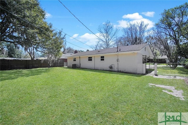 back of property with a yard, stucco siding, and fence