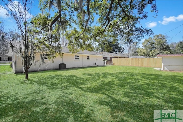 view of yard with central AC unit and fence