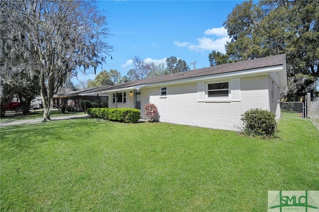 ranch-style house with a front yard, fence, and brick siding