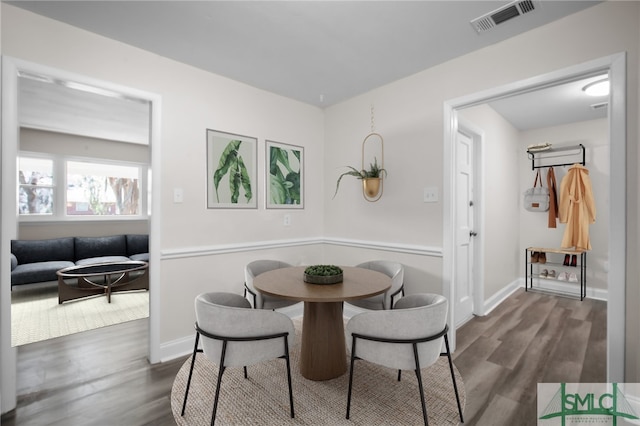 dining area with dark wood-style floors, visible vents, and baseboards