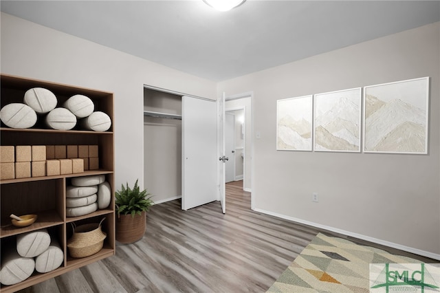 bedroom featuring a closet, baseboards, and wood finished floors