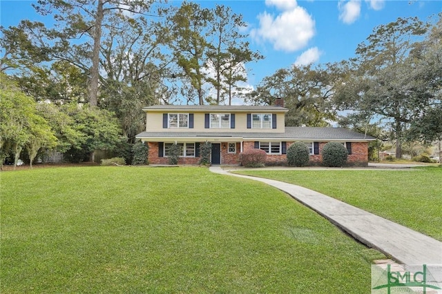 view of front of house featuring brick siding, a chimney, and a front yard