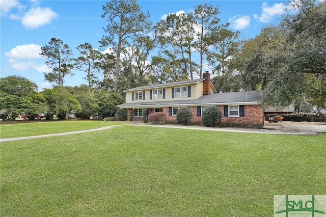 view of front of property with brick siding, a chimney, and a front yard