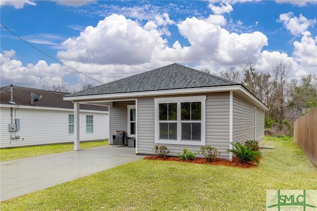 back of property with a patio area, fence, a lawn, and a shingled roof