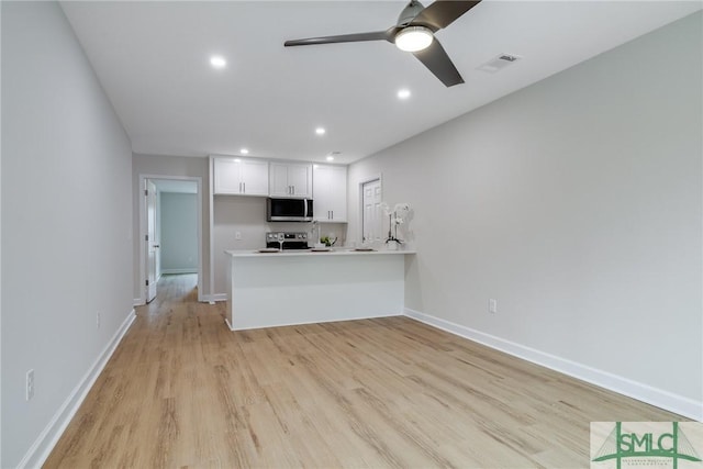 kitchen featuring ceiling fan, light wood-type flooring, light countertops, appliances with stainless steel finishes, and white cabinetry