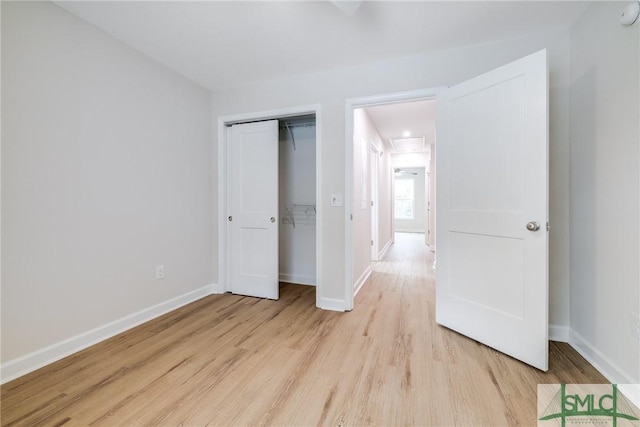 unfurnished bedroom featuring a closet, baseboards, and light wood-style floors