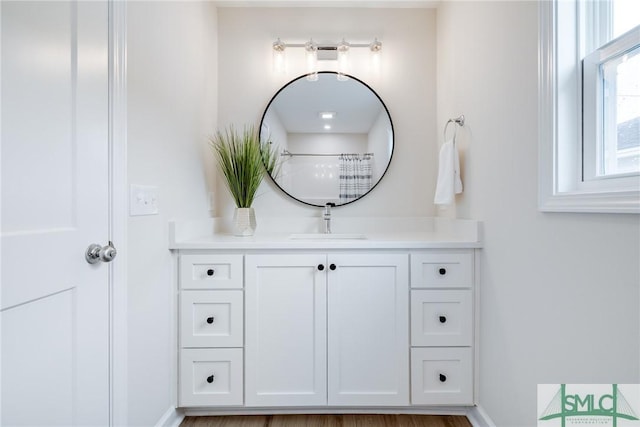 bathroom with vanity, curtained shower, and baseboards