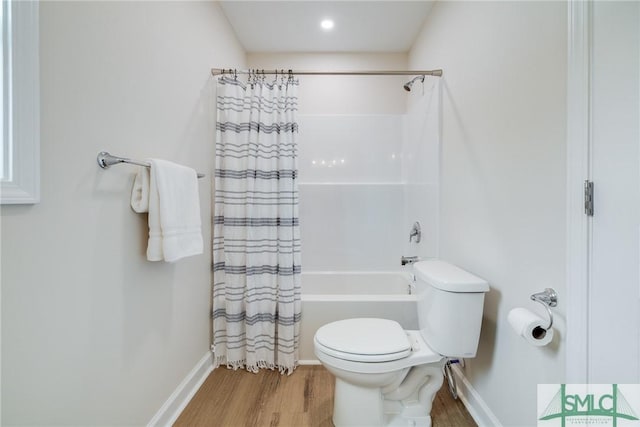 bathroom featuring baseboards, toilet, wood finished floors, and shower / tub combo with curtain