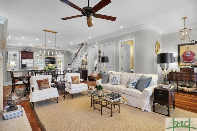 living area featuring stairs, ceiling fan, recessed lighting, and ornamental molding