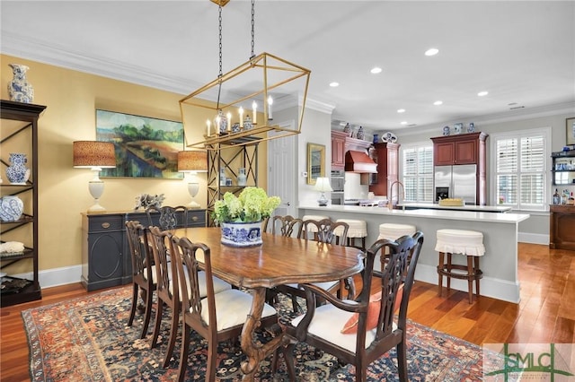 dining room with wood finished floors, recessed lighting, crown molding, baseboards, and a chandelier