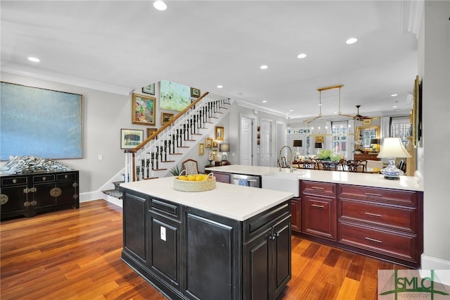 kitchen featuring dark brown cabinets, a center island, crown molding, and light countertops