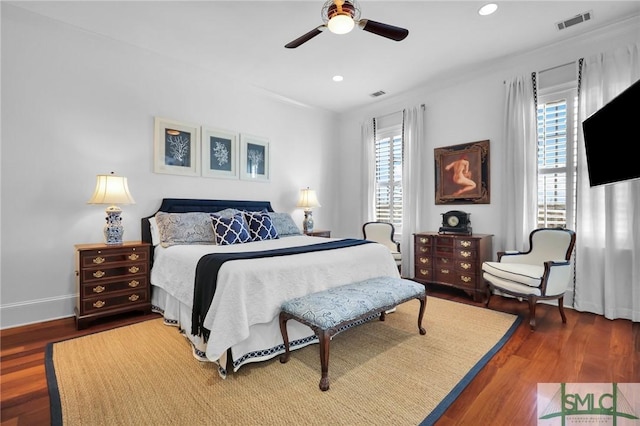 bedroom with visible vents, multiple windows, and wood finished floors