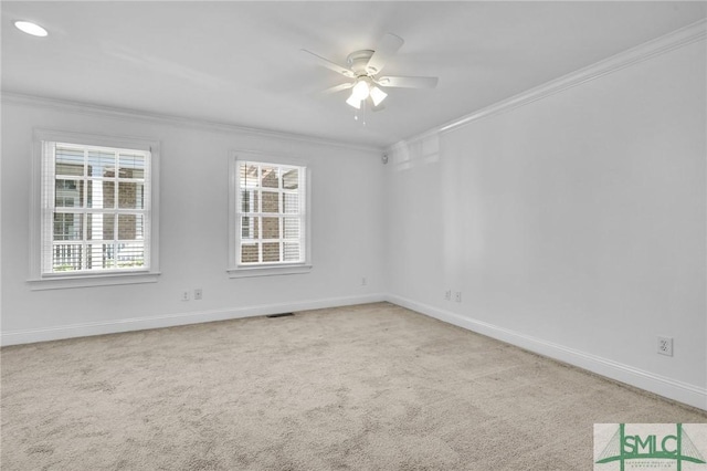 spare room with ceiling fan, baseboards, carpet, and ornamental molding